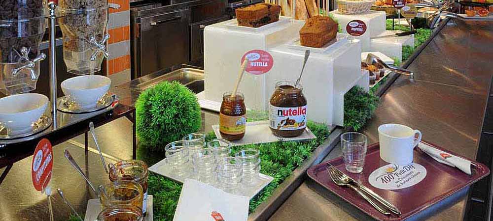 Buffet de petit-déjeuner varié avec pains, Nutella, céréales et accessoires